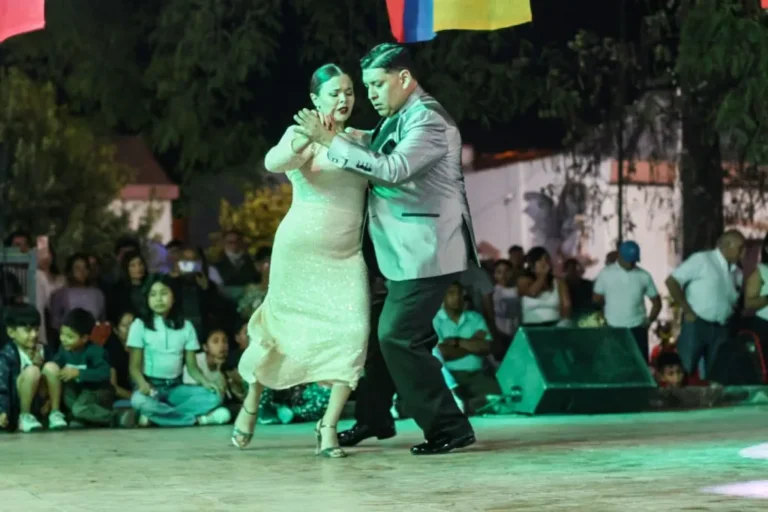 Personas bailando tango en el Paseo de los Poetas de Salta durante una clase al aire libre