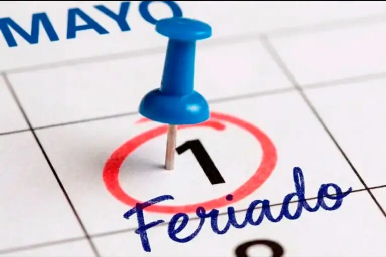 Personas trabajando en una oficina con calendario de feriados argentinos al fondo