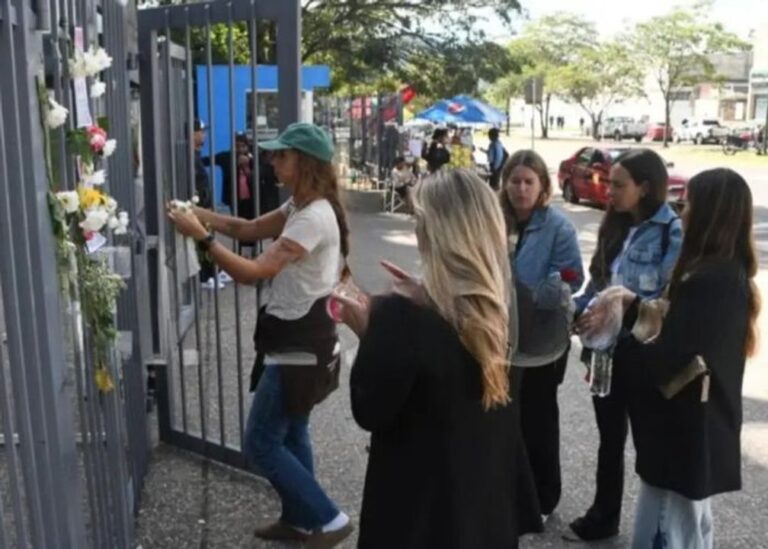 Personas colocando flores a las puertas de la Ciudad Judicial de Salta.