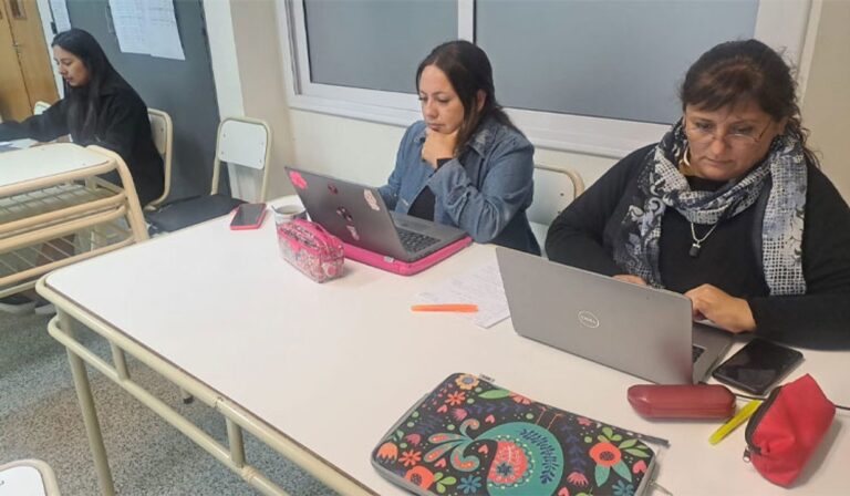 Estudiantes adultos en aula virtual usando computadoras