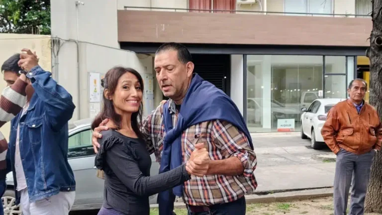 Personas participando de una clase de tango en un salón comunitario.