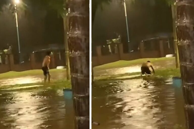 Hombre siendo consolado por vecinos en una calle anegada de Tucumán