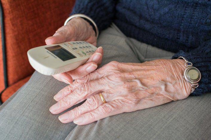 Mujer mayor hablando por teléfono, ilustración de estafa telefónica